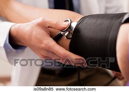 Mid adult doctor using stethoscope and blood pressure cuff on patient, close up View Large Photo Image Stock Photography - Mid adult doctor using stethoscope and blood pressure cuff on patient, close up. Fotosearch