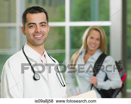Stock Photo - Mid adult doctor with stethoscope smiling, portrait. Fotosearch