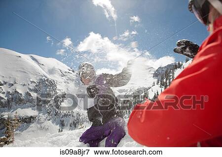 Mid adult man and young woman in skiwear having snowball fight View Large Photo Image Stock Photo - Mid adult man and young woman in skiwear having snowball fight. Fotosearch