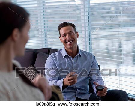 Mid adult man relaxing with young woman and glass of wine View Large Photo Image Stock Photography - Mid adult man relaxing with young woman and glass of wine. Fotosearch