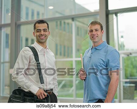 Mid adult men together in lobby, smiling View Large Photo Image Picture - Mid adult men together in lobby, smiling. Fotosearch