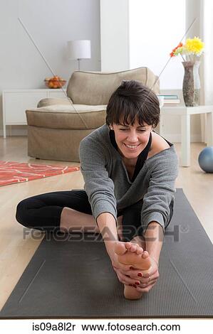 Mid adult woman doing yoga at home View Large Photo Image Stock Photography - Mid adult woman doing yoga at home. Fotosearch