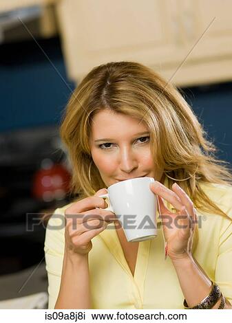 Stock Image - Mid adult woman drinking from cup, portrait. Fotosearch