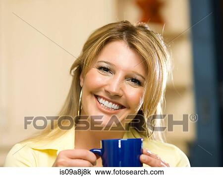 Mid adult woman holding cup and smiling, portrait View Large Photo Image Stock Image - Mid adult woman holding cup and smiling, portrait. Fotosearch