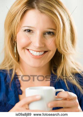 Mid adult woman holding cup and smiling, portrait View Large Photo Image Stock Photo - Mid adult woman holding cup and smiling, portrait. Fotosearch