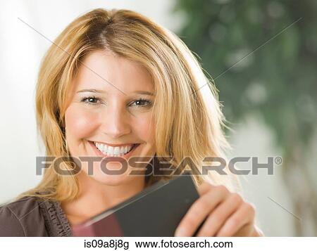 Mid adult woman holding notebook and smiling View Large Photo Image Stock Image - Mid adult woman holding notebook and smiling. Fotosearch