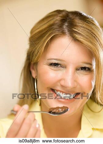 Mid adult woman holding spoon of chocolate dessert, portrait View Large Photo Image Picture - Mid adult woman holding spoon of chocolate dessert, portrait. Fotosearch