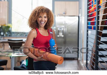 Mid adult woman in holding yoga mat and water bottle, portrait View Large Photo Image Stock Photography - Mid adult woman in holding yoga mat and water bottle, portrait. Fotosearch