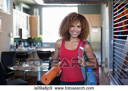 Mid adult woman in red vest and holding yoga mat, portrait View Large Photo Image Stock Photo - Mid adult woman in red vest and holding yoga mat, portrait. Fotosearch