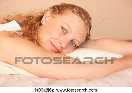 Mid adult woman relaxing on bed, portrait View Large Photo Image Stock Photo - Mid adult woman relaxing on bed, portrait. Fotosearch