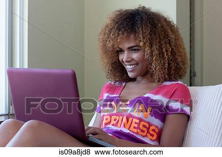 Mid adult woman sitting using laptop, smiling View Large Photo Image Stock Photo - Mid adult woman sitting using laptop, smiling. Fotosearch