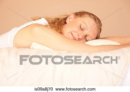 Mid adult woman sleeping on bed, smiling View Large Photo Image Stock Image - Mid adult woman sleeping on bed, smiling. Fotosearch
