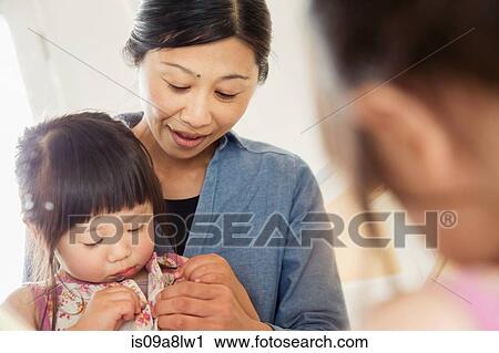 Stock Image - Mirror portrait of mother and toddler. Fotosearch