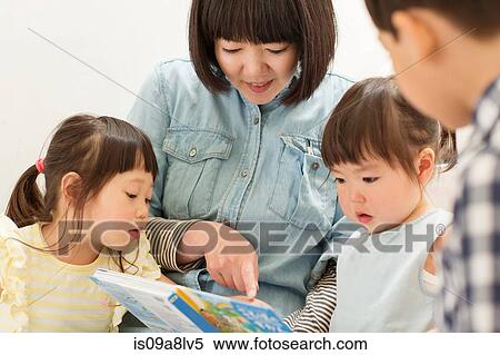 Mother and children looking at storybook View Large Photo Image Stock Photography - Mother and children looking at storybook. Fotosearch