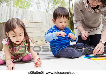 Mother and two children drawing in garden View Large Photo Image Stock Image - Mother and two children drawing in garden. Fotosearch