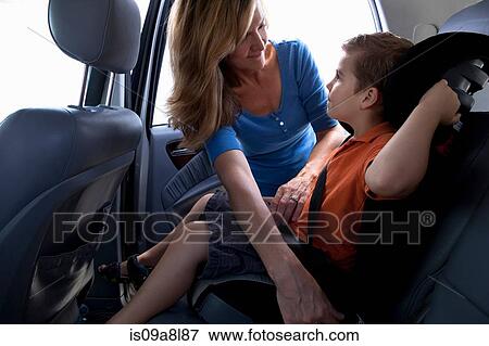 Mother fastening child safety seat belt in car View Large Photo Image Stock Photo - Mother fastening child safety seat belt in car. Fotosearch