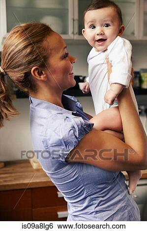 Mother holding baby girl, smiling View Large Photo Image Stock Photograph - Mother holding baby girl, smiling. Fotosearch