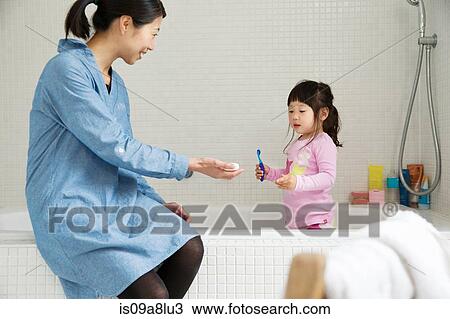 Mother with female toddler standing in bath with tooth brush View Large Photo Image Stock Image - Mother with female toddler standing in bath with tooth brush. Fotosearch