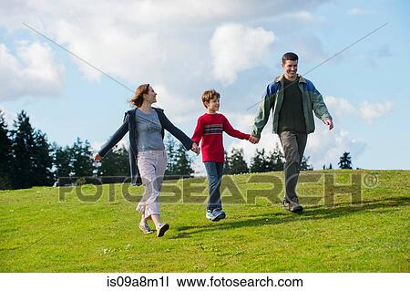 Stock Image - Parents and son walking hand in hand. Fotosearch
