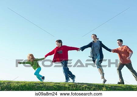 Parents and two children running and holding hands View Large Photo Image Picture - Parents and two children running and holding hands. Fotosearch