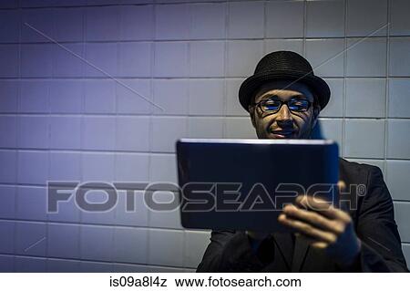 Stock Photo - Portrait of man using digital tablet underground. Fotosearch