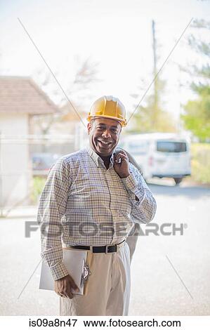 Portrait of man wearing hard hat and carrying clipboard View Large Photo Image Stock Photo - Portrait of man wearing hard hat and carrying clipboard. Fotosearch