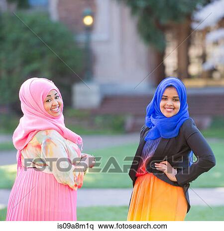 Stock Photography - Portrait of two female friends in park wearing colorful headscarves. Fotosearch