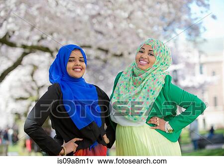 Portrait of two young females in park with hands on hips View Large Photo Image Stock Photo - Portrait of two young females in park with hands on hips. Fotosearch