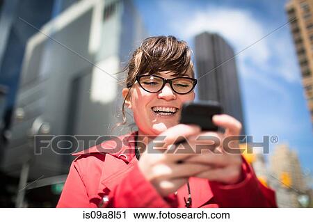 Portrait of woman in city looking at smartphone View Large Photo Image Stock Image - Portrait of woman in city looking at smartphone. Fotosearch