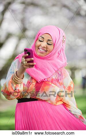 Stock Photography - Portrait of young female with matching mobile and headscarf. Fotosearch