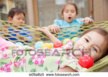 Portrait of young girl in hammock with colored balls View Large Photo Image Stock Photography - Portrait of young girl in hammock with colored balls. Fotosearch