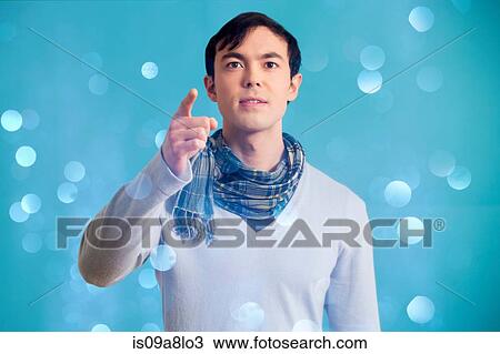 Stock Image - Portrait of young man wearing blue jumper and scarf. Fotosearch