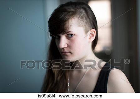 Stock Image - Portrait of young woman looking at camera. Fotosearch