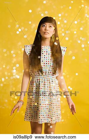 Stock Photo - Portrait of young woman wearing spotted dress with glitter. Fotosearch