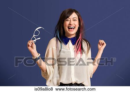 Portrait of young woman with dyed hair holding glasses View Large Photo Image Stock Photo - Portrait of young woman with dyed hair holding glasses. Fotosearch