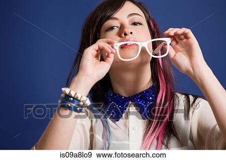 Portrait of young woman with dyed hair holding glasses View Large Photo Image Stock Photo - Portrait of young woman with dyed hair holding glasses. Fotosearch