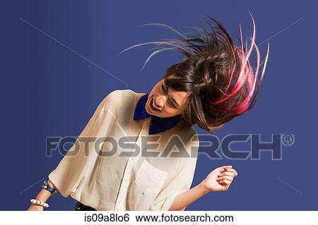 Stock Photograph - Portrait of young woman with dyed hair dancing. Fotosearch