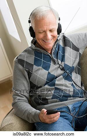 Senior man wearing headphones listening to music View Large Photo Image Stock Image - Senior man wearing headphones listening to music. Fotosearch