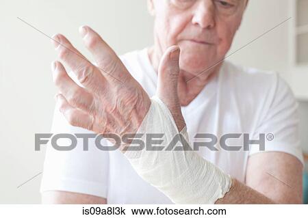 Stock Image - Senior man with bandage on wrist. Fotosearch