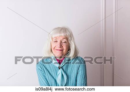 Stock Image - Senior woman with eyes closed, smiling. Fotosearch