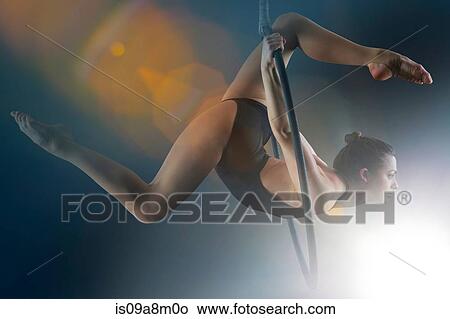 Side view of aerialist performing on hoop View Large Photo Image Picture - Side view of aerialist performing on hoop. Fotosearch