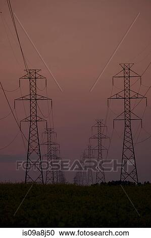 Stock Image - Silhouette of electrical towers at sunset. Fotosearch