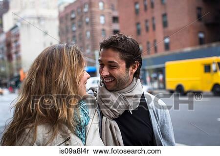 Stock Photography - Smiling couple walking down city street. Fotosearch