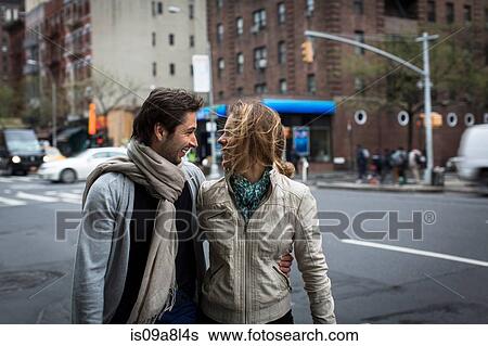 Stock Photograph - Smiling couple walking together down city street. Fotosearch