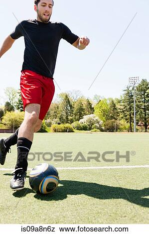 Soccer player running and dribbling ball View Large Photo Image Stock Photo - Soccer player running and dribbling ball. Fotosearch