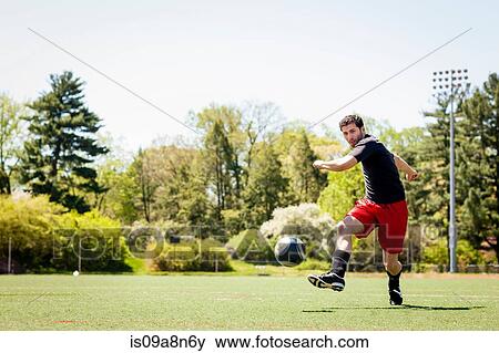 Soccer player running and kicking ball View Large Photo Image Stock Photo - Soccer player running and kicking ball. Fotosearch