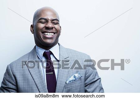 Picture - Studio portrait of businessman laughing. Fotosearch