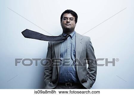 Stock Image - Studio portrait of businessman with flyaway tie. Fotosearch
