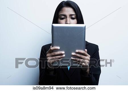 Picture - Studio portrait of businesswoman holding digital tablet. Fotosearch