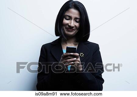 Studio portrait of businesswoman looking at cellphone View Large Photo Image Stock Image - Studio portrait of businesswoman looking at cellphone. Fotosearch